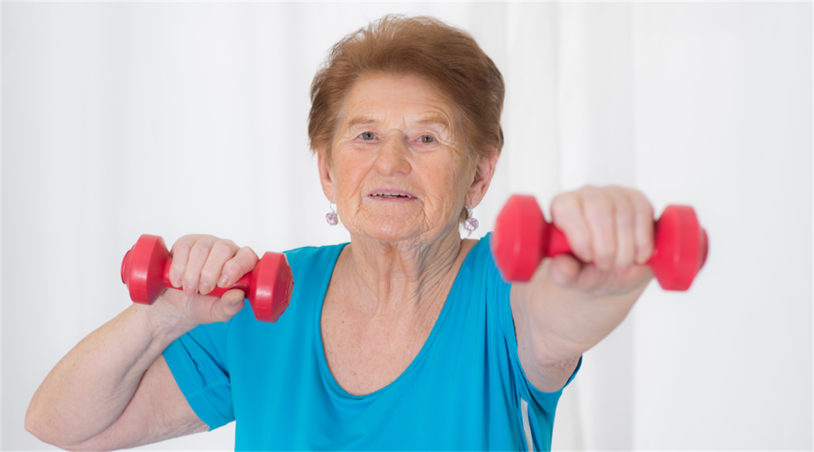 Older lady wearing blue shirt doing exercise with small red dumbbellsFriendly Group Class_Digital_web-04.png