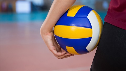 Person holding volleyball on side of hip