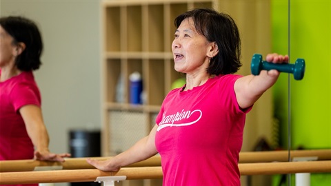 Female holding weight in group fitness class