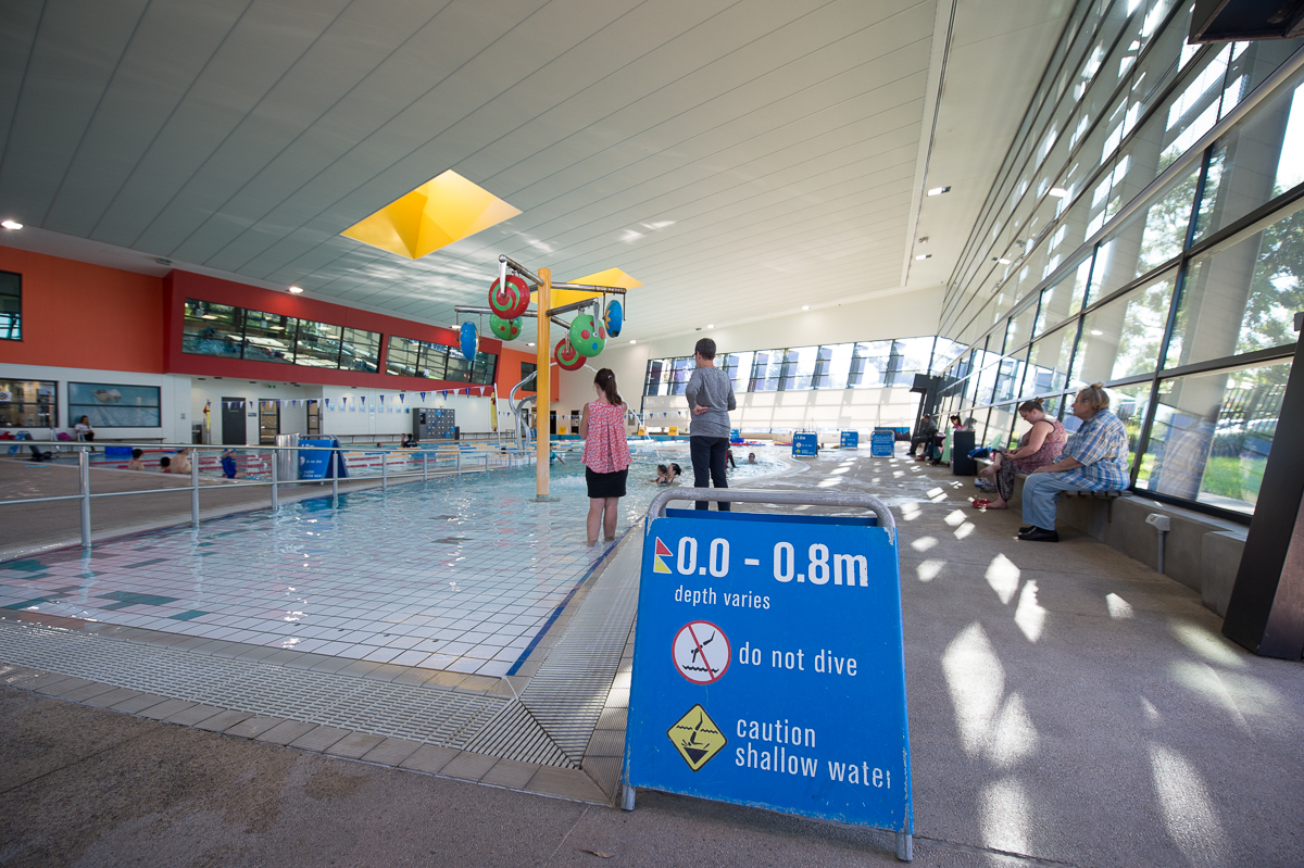 Shallow swimming pool with two people standing in the background