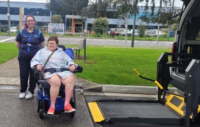 Visitor in wheelchair with staff member.jpg