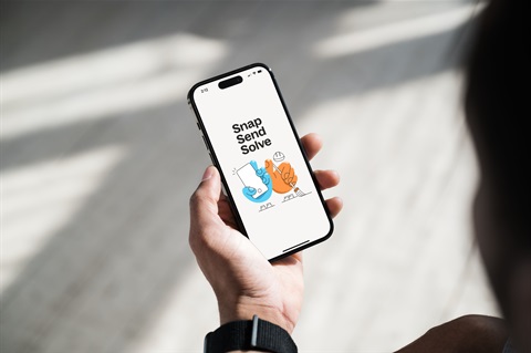 Hand holding phone displaying Snap Send Solve app.jpg