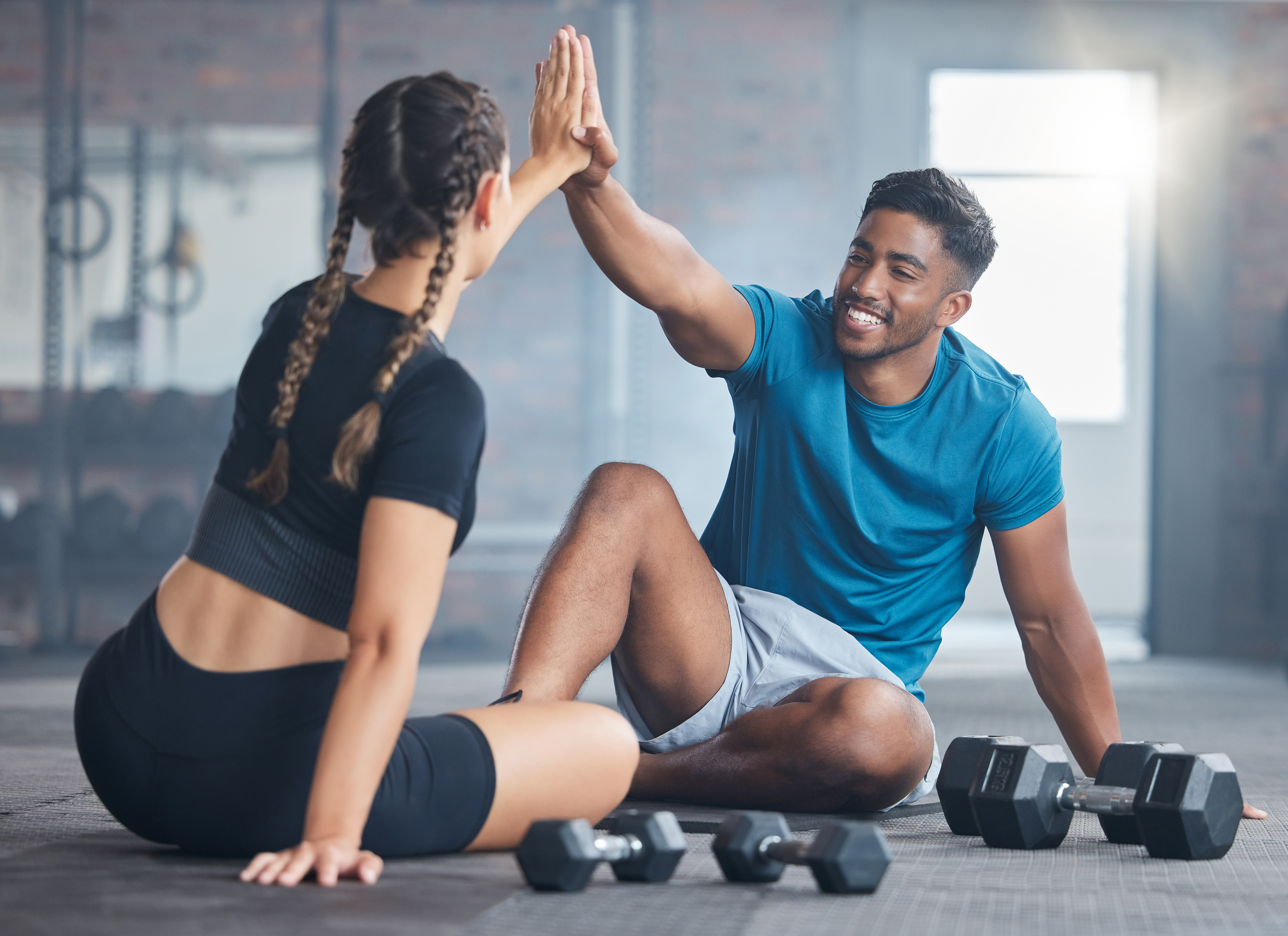 man and woman high fiving on the gym floor.jpeg